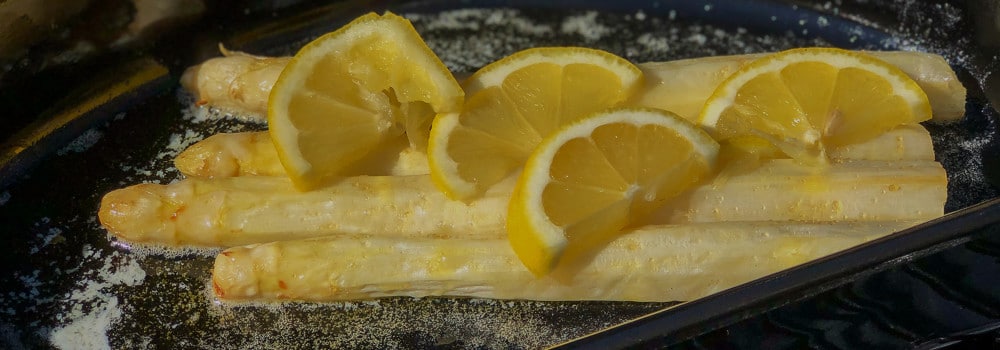 Weißer Spargel mit Zitronenscheiben in Butter