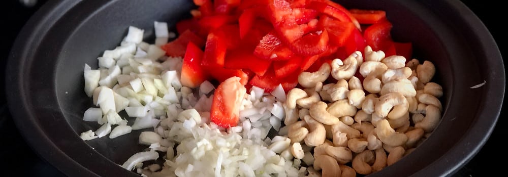 Zwiebeln, Knoblauch, Fenchel, Paprika und Cashewkerne in Tajine