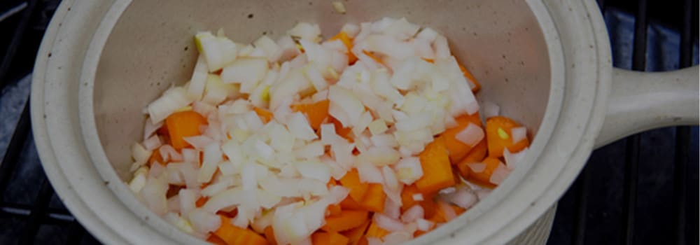 Zwiebel- und Möhrenwürfel im Topf