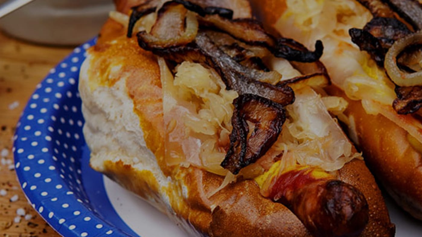 Hotdog auf Bayrisch mit Laugenstange, Bratwurst, Sauerkraut und Röstzwiebeln