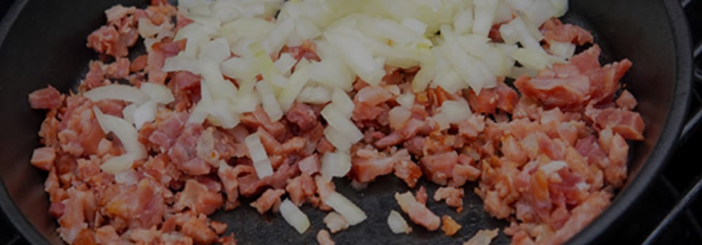 Speck und Zwiebeln in der Gusspfanne