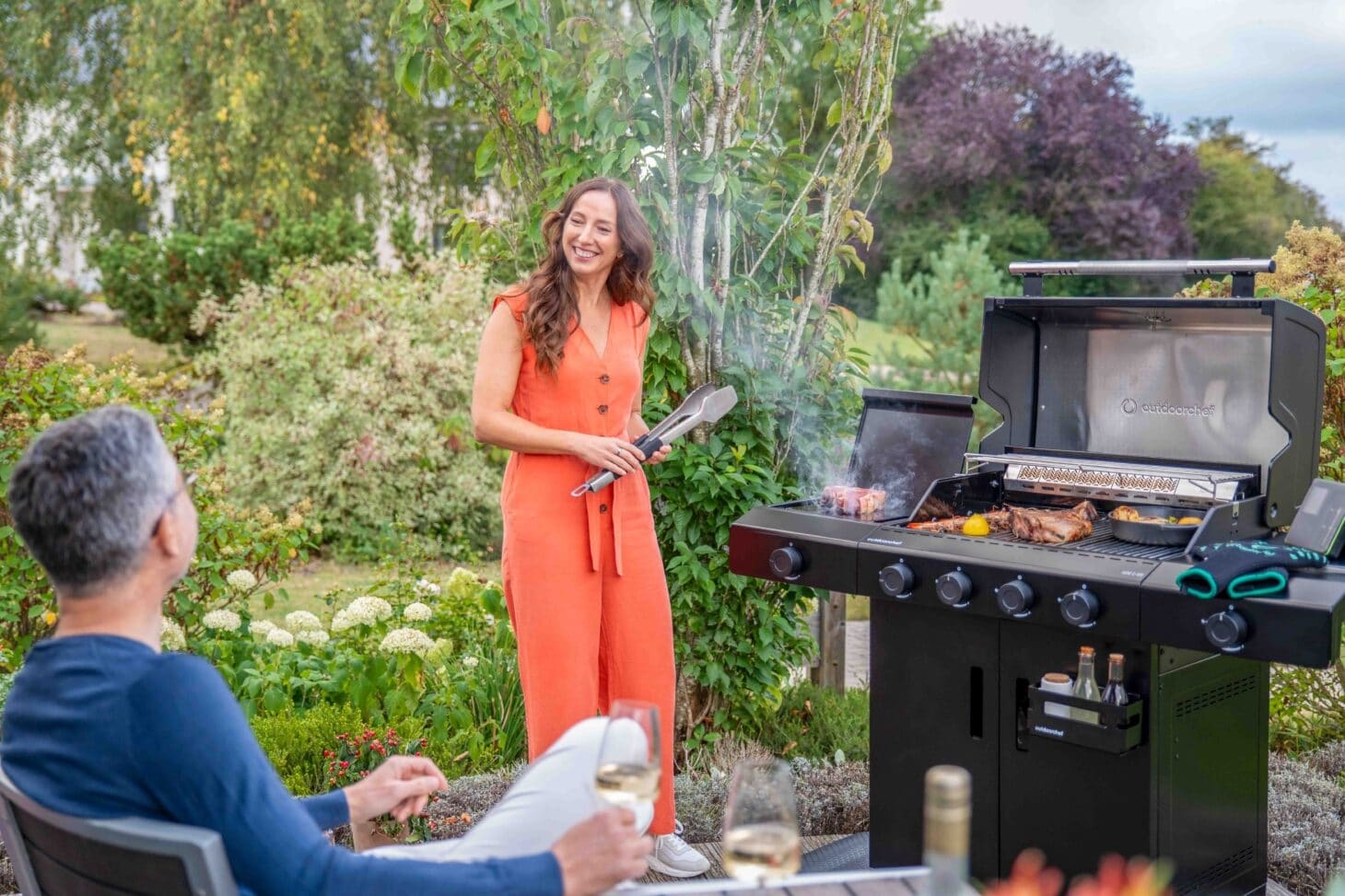 Schwarze Outdoorchef C-Linie Gasgrillstation auf einer Terrasse mit magnetischer Hakenleiste und integrierter Blazing Zone