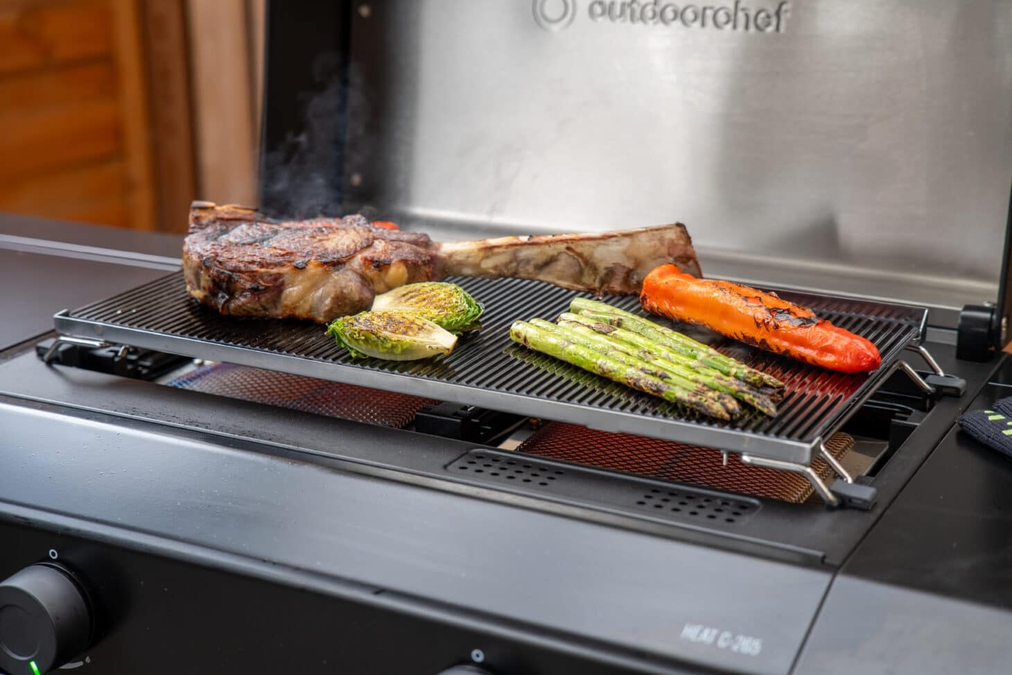 Outdoorchef Planchagrill Heat C-265 mit Blazing Glas, Steak, Spargel und Paprika beim Grillen