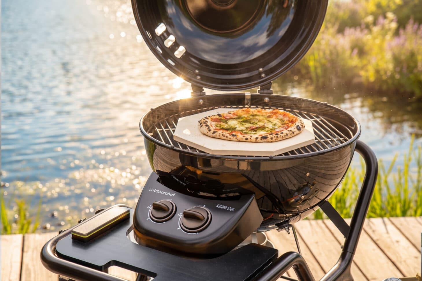 Outdoorchef Ascona 570 G mit Pizza auf dem Pizzastein am See