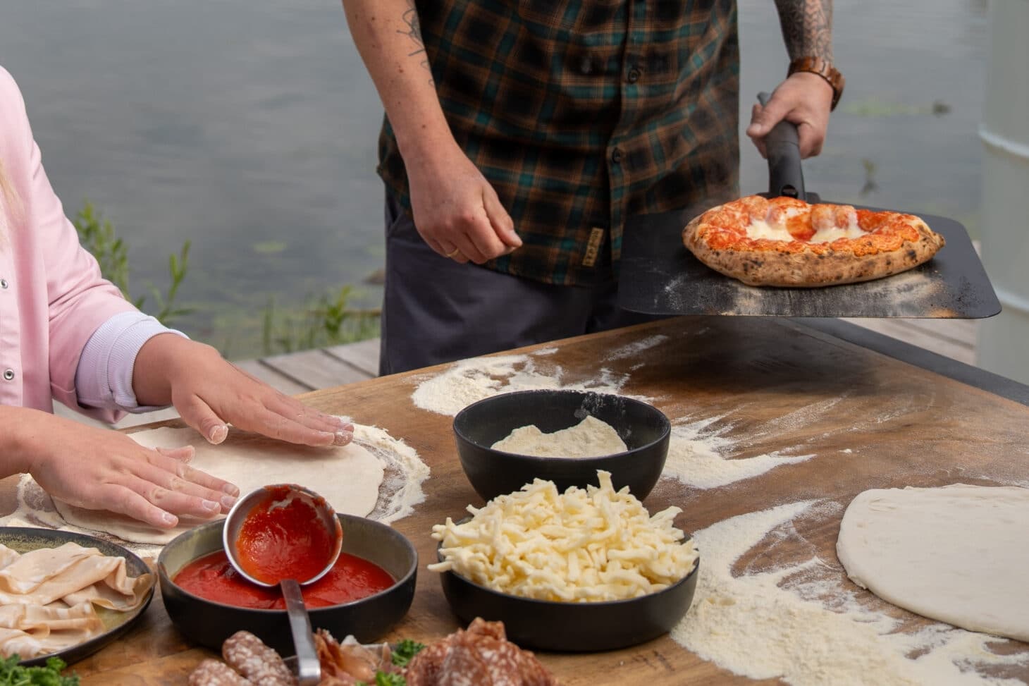 Outdoorchef PRISMO Pizzaofen mit frisch gebackener Pizza und gemeinsamer Zubereitung am See