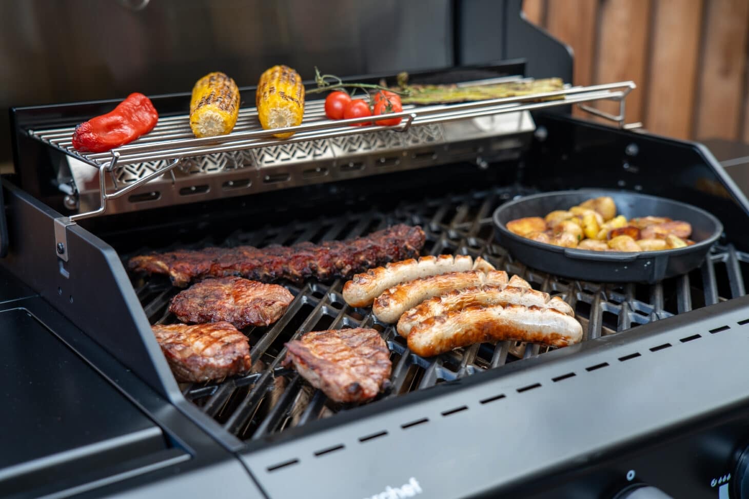 Outdoorchef Heat C mit Steaks, Würsten, Ribs, Mais, Paprika und Kartoffeln beim Grillen